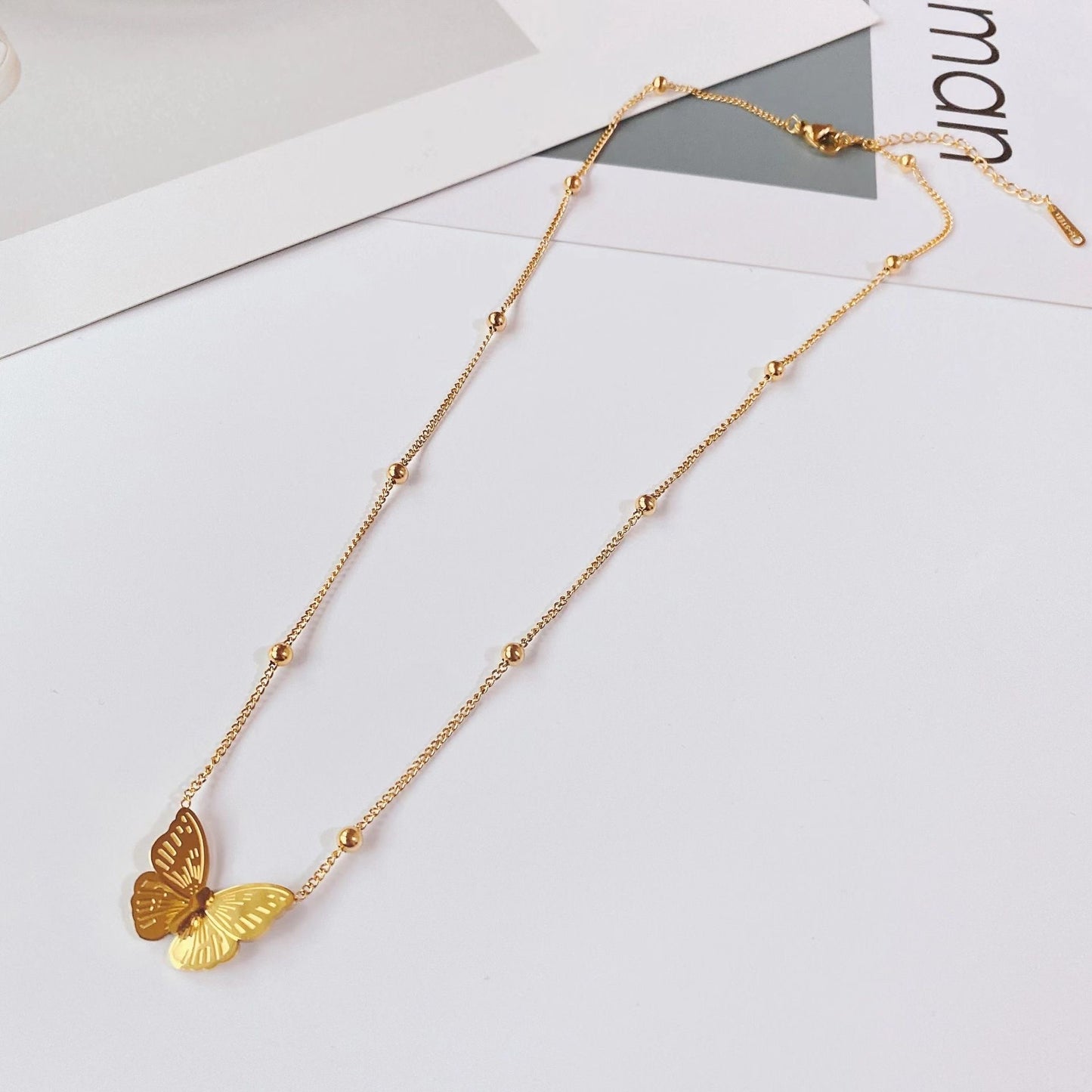 Collana pendente a farfalla minimalista da donna in acciaio al titanio con design a catena a O