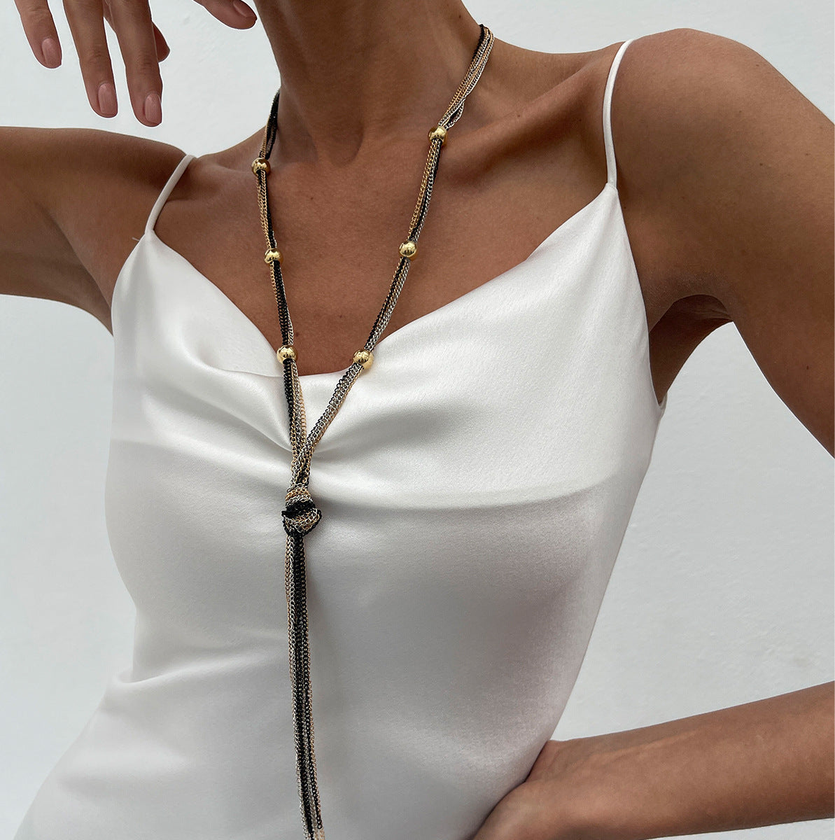 Collar de mujer minimalista y geométrico con diseño en Y, con capas de metal y colgante de borla