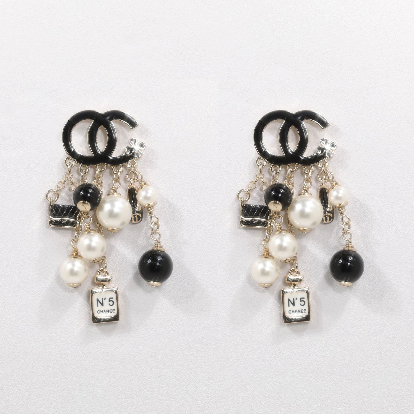 Elegante broche de lujo con letras bañadas en latón y borla
