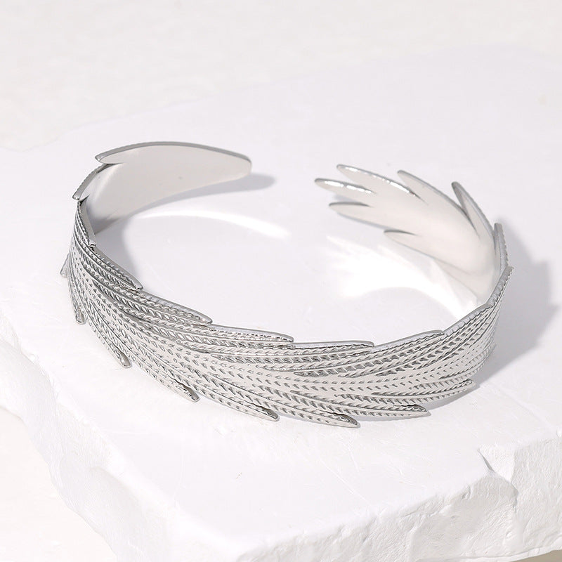 Pulsera de acero inoxidable con forma de pluma minimalista y acabado chapado para mujer