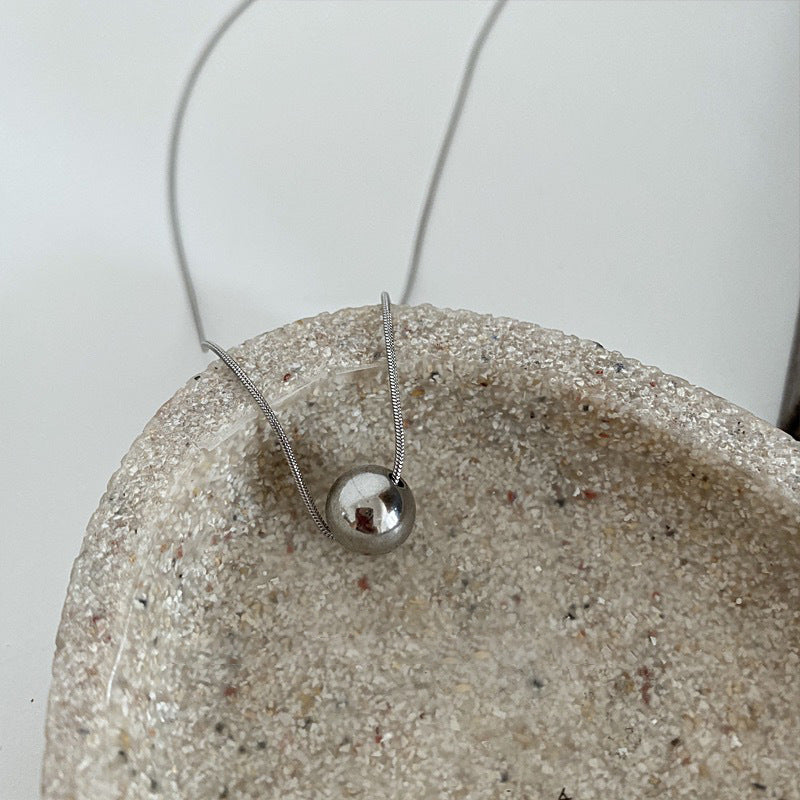 Collana da donna minimalista con pendente a sfera in acciaio al titanio con placcatura in oro e catena a serpente