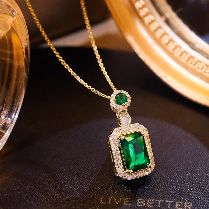 Collana con pendente geometrico di ispirazione vintage in acciaio al titanio con intarsio in rame placcato oro e inserti in cristallo verde su catena a maglie ovali