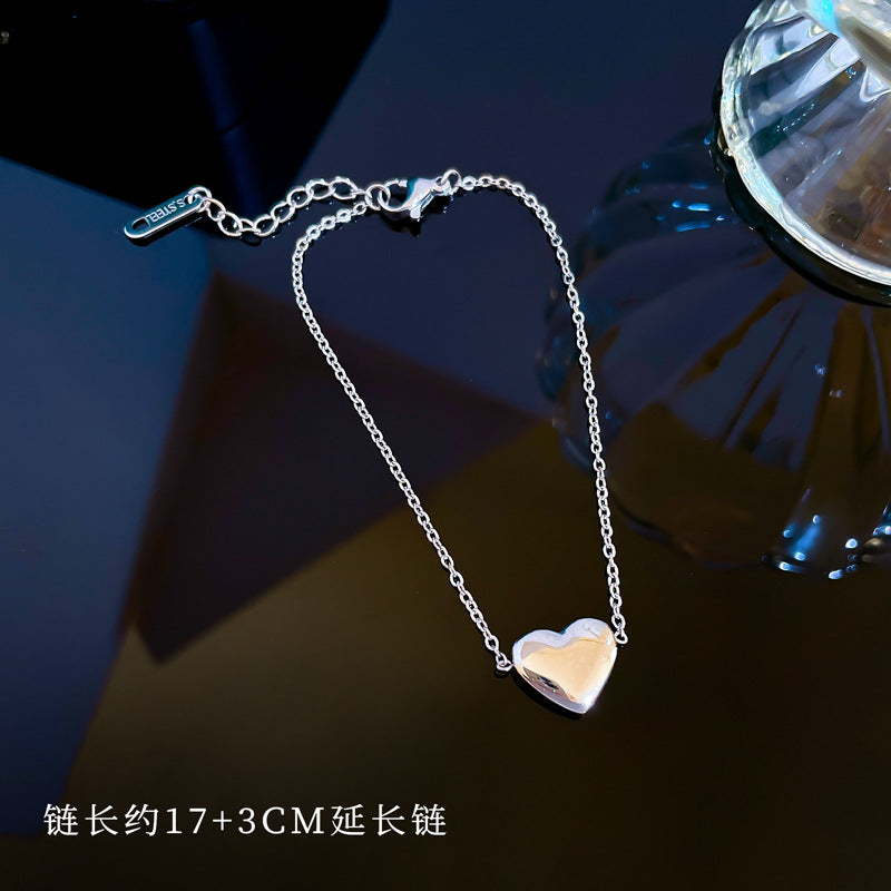 Bracciale a Cuore Minimalista in Acciaio al Titanio Tonalità Fredda per Donna con Intarsio Dorato e Texture Ondulata