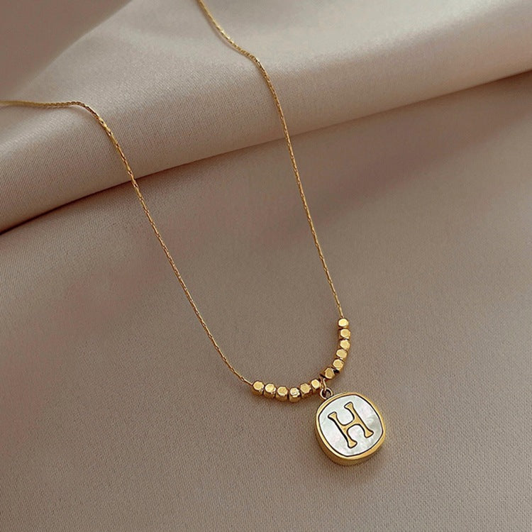 Collana con pendente a faccina sorridente minimalista da donna in acciaio al titanio con intarsio in madreperla e finitura placcata