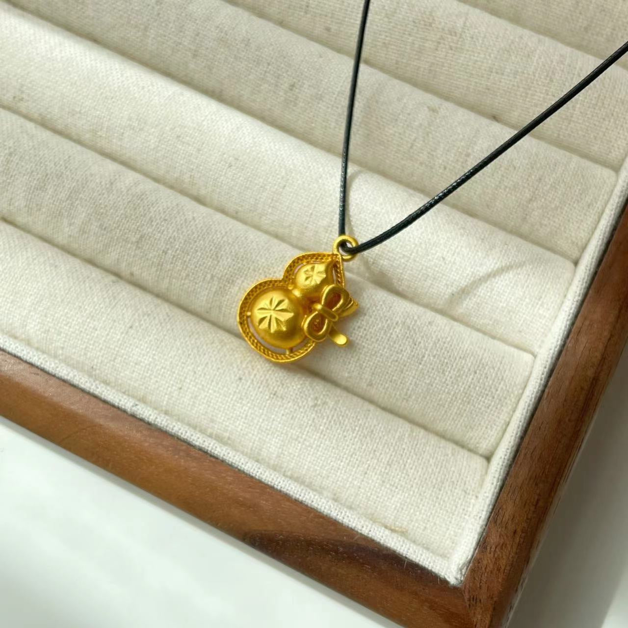 Collana con ciondolo a baccello di loto e zucca in stile etnico da donna con charm in rame placcato oro, dettaglio nappa, catena in cordino nero