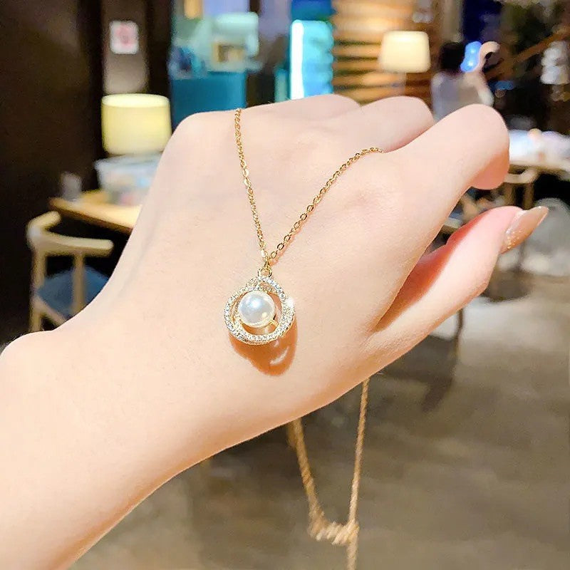 Collana con ciondolo geometrico in acciaio al titanio placcato oro 18 carati, strass micro-incastonati, dettagli in perle e catena ondulata