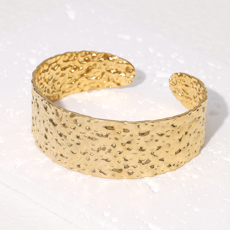 Bracciale da donna in acciaio inossidabile con texture a martellatura irregolare, finitura lucida e design a fascia larga