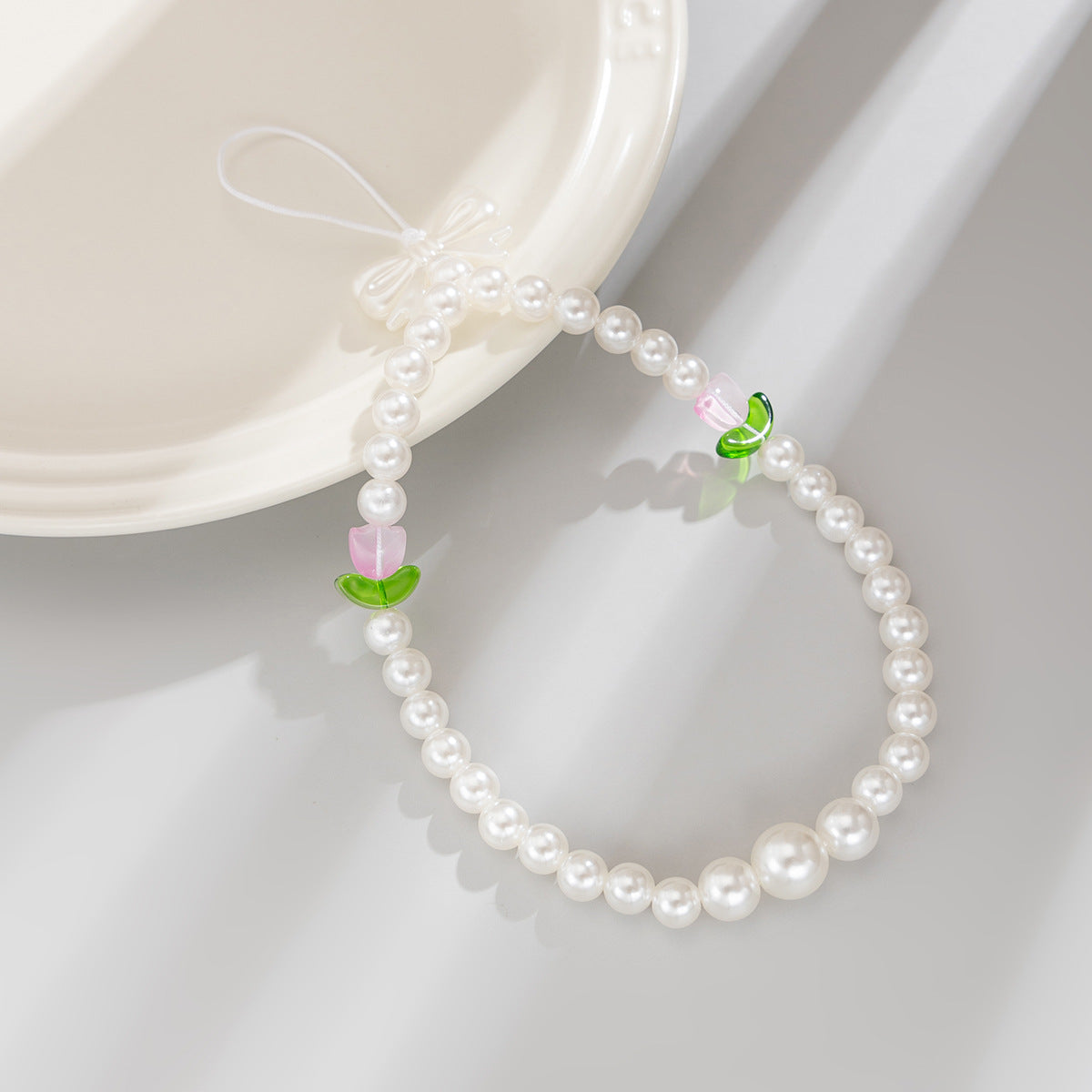 Bonita correa de teléfono con nudo de lazo de tulipán y perlas de imitación para mujeres, accesorio tejido a mano con dulce estilo floral