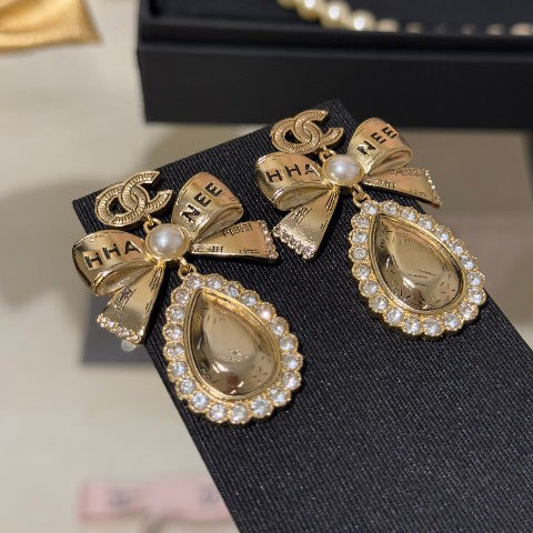 Orecchini vintage in ottone placcato oro con fiocco e strass, perno in argento sterling 925