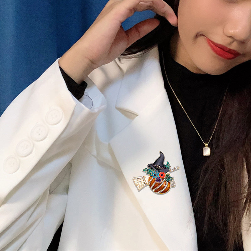 Broche con temática de Halloween, diseño de calabaza con sombrero de bruja y escoba en aleación de zinc con acabado esmaltado y detalles de diamantes de imitación