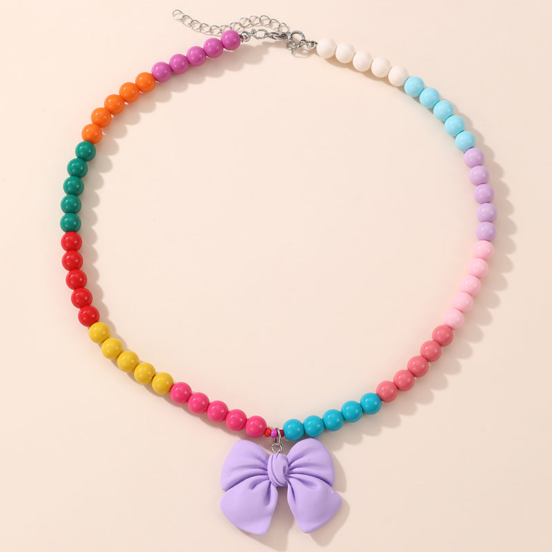 Lindo Collar de Resina con Forma de Lazo para Niñas con Acabado Pintado en Diseño Multicolor, Joyería Infantil Dulce y Juguetona