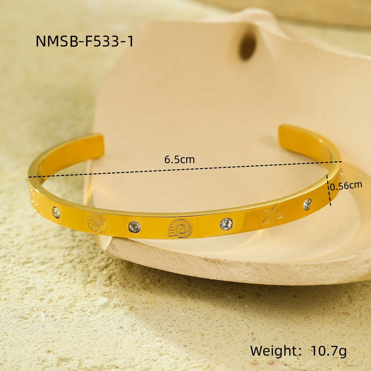 Brazalete abierto de acero de titanio con diseño geométrico, inspirado en el océano, con incrustaciones de pedrería y acabado chapado