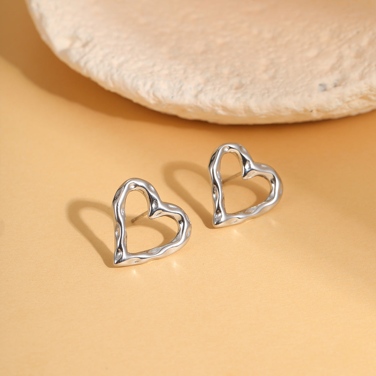 Pendientes de tuerca de corazón hueco de acero de titanio de moda minimalista con baño de oro de 18 quilates para mujer