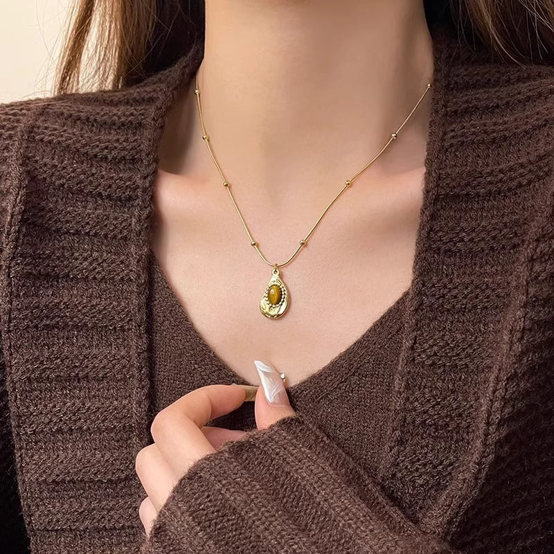 Collana da donna stile vintage in acciaio al titanio placcato oro con pendente irregolare geometrico in ambra, catena per clavicola