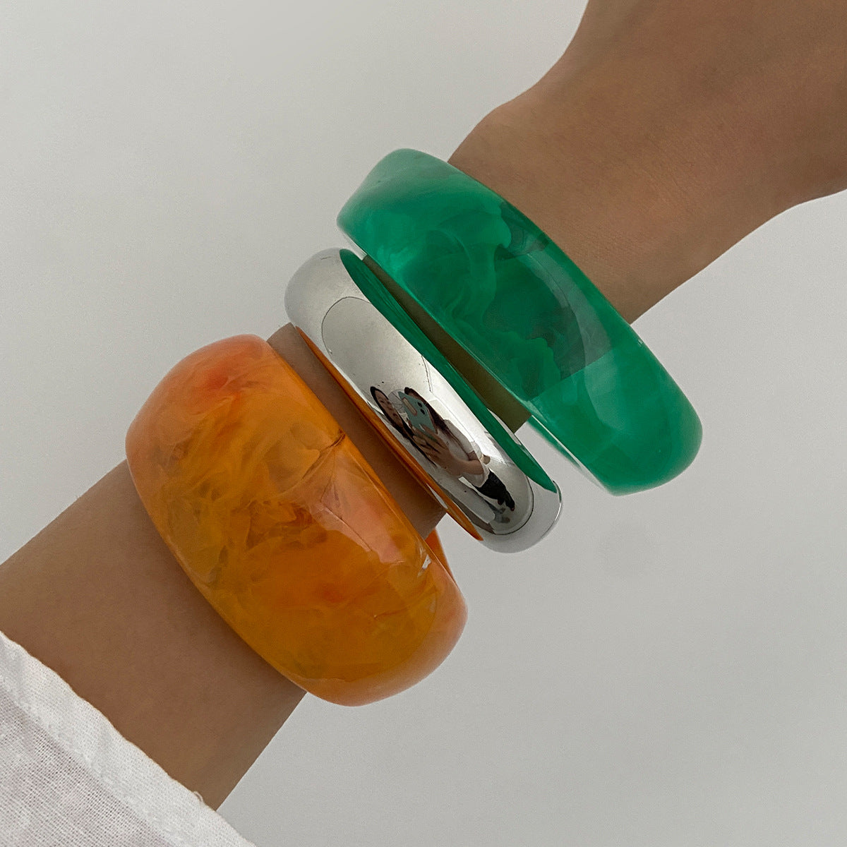 Bracciale minimalista in resina con forme geometriche irregolari, effetto sfumato e finitura placcata