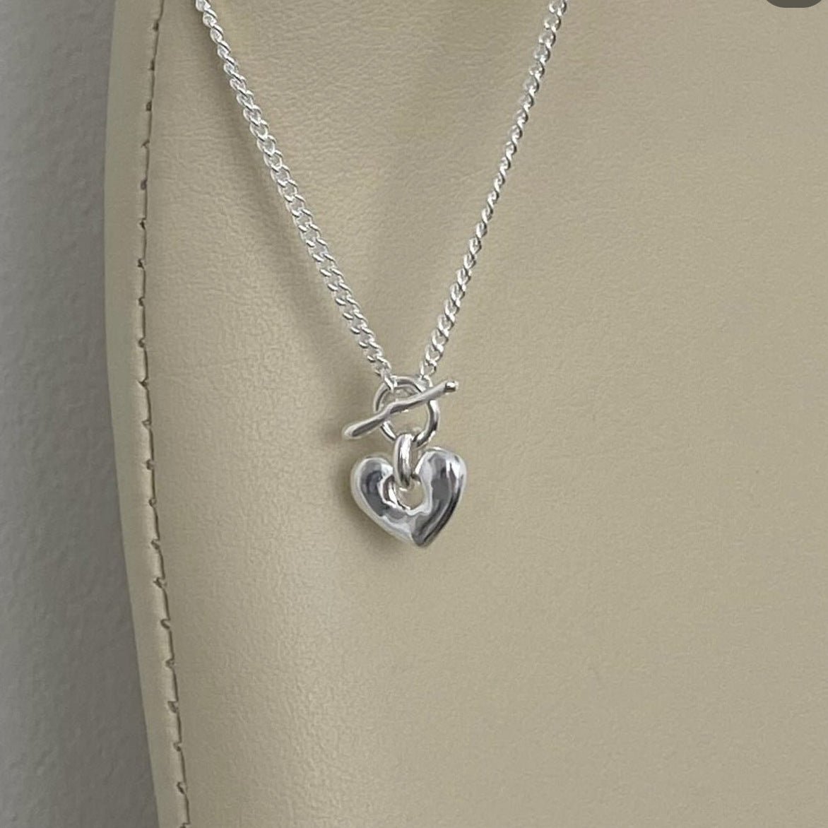 Collana minimalista con chiusura a T in argento sterling 925 a forma di cuore, finitura lucida e catena a maglia incrociata delicata