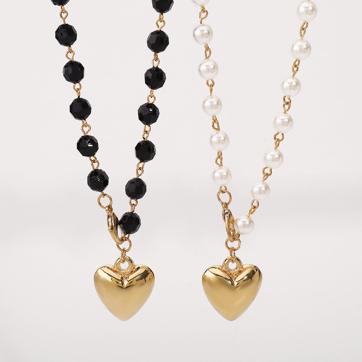 Collar de doble capa minimalista con colgante de corazón, acentos de perlas simuladas y acabado chapado en oro para mujer