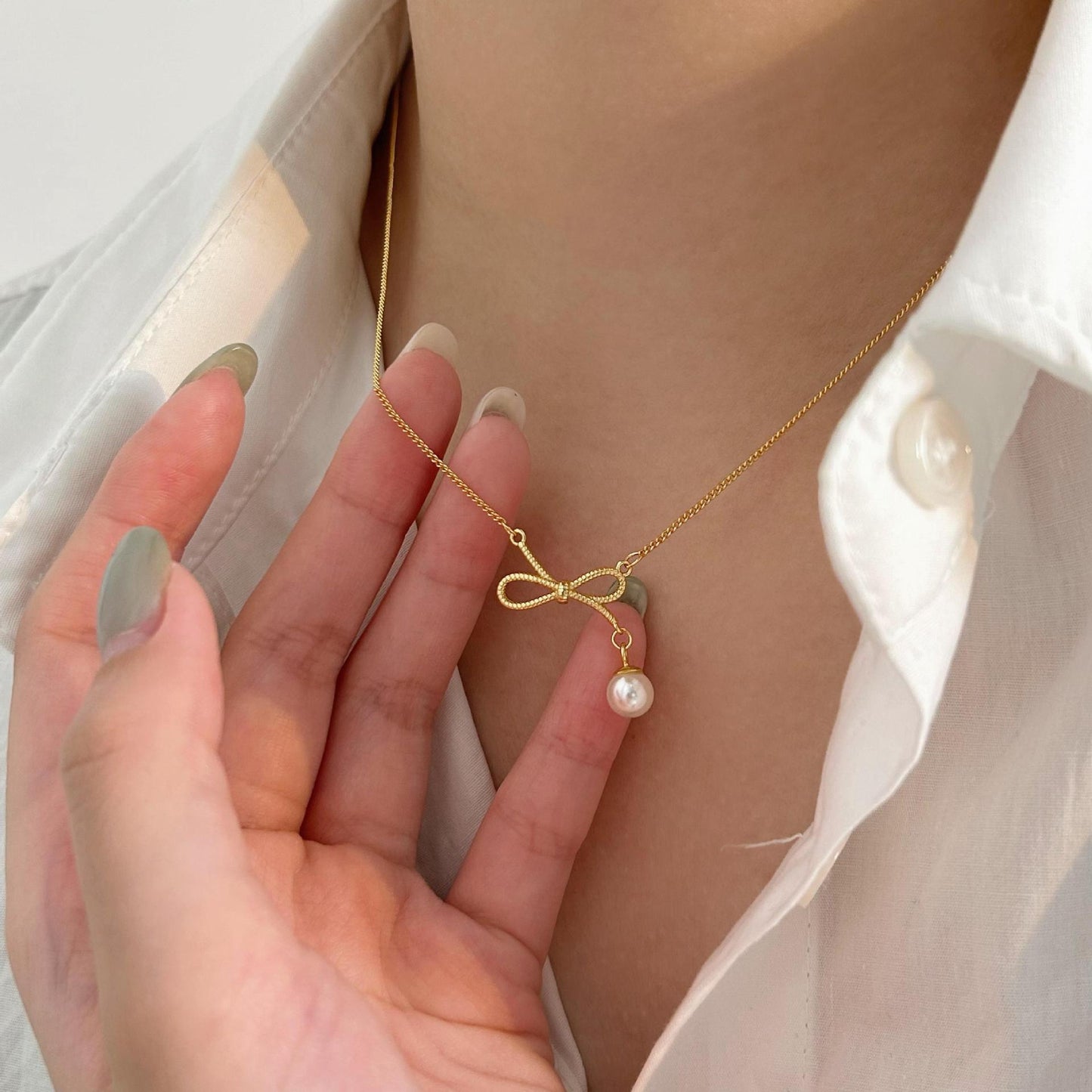 Collana minimalista a forma di fiocco in argento sterling 925 con accento di perla su catena a croce