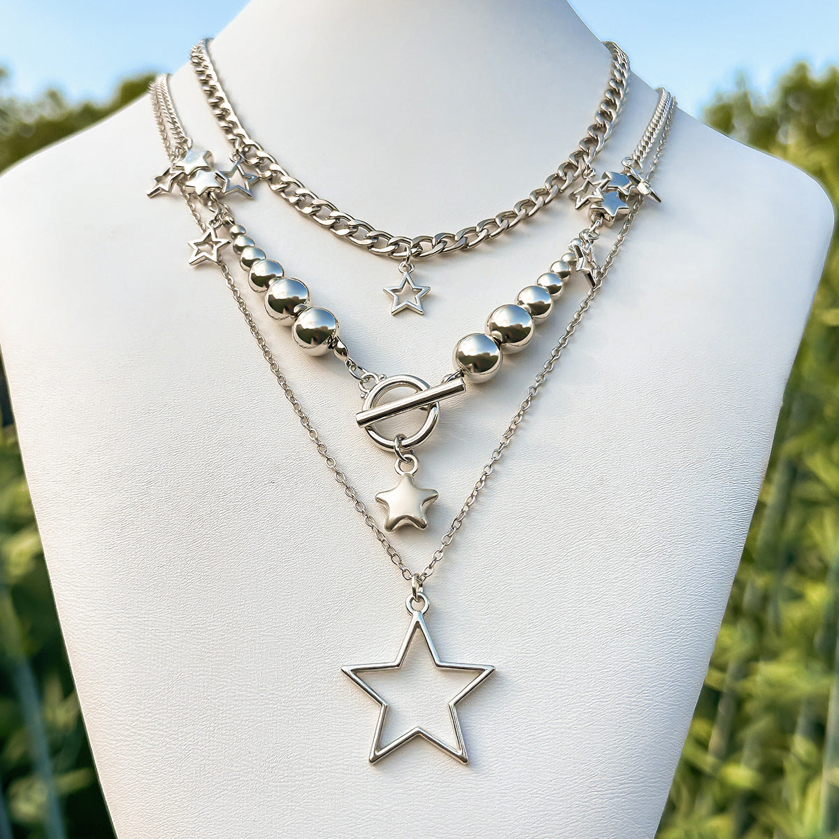 Collana pendente a forma di stella tagliente con nappe da donna, con struttura in lega di zinco e finitura galvanizzata su catenina a sfere