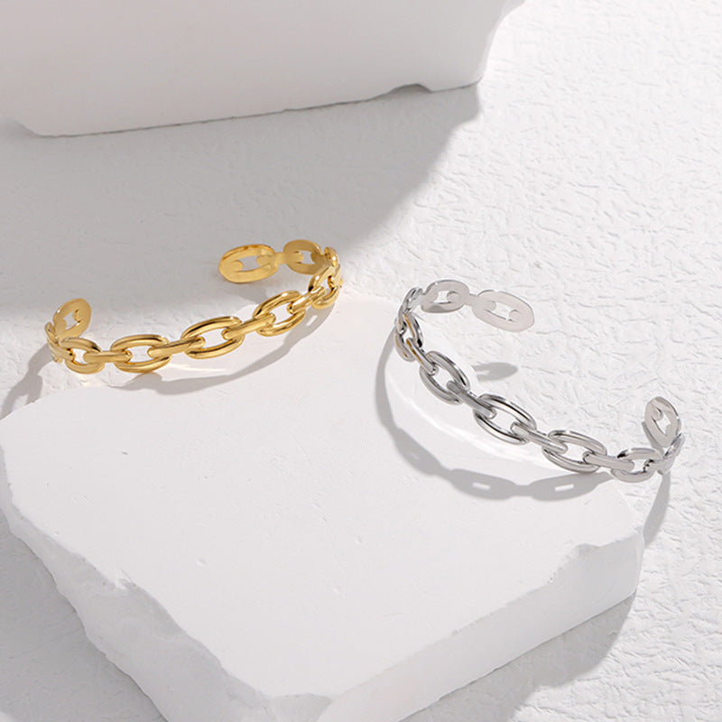 Pulsera Minimalista de Acero de Titanio Abierta para Mujer con Acabado Chapado y Detalle de Cadena