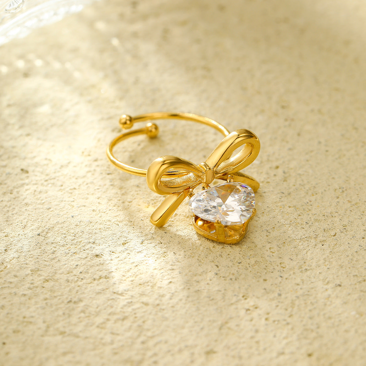 Anillo con colgante de corazón en forma de lazo estilo lujo para mujer, hecho de acero de titanio con incrustaciones de diamantes de imitación y acabado chapado