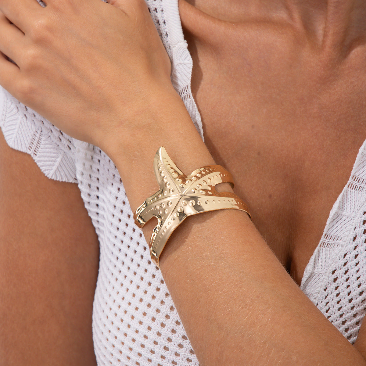 Pulsera metálica con forma de estrella de mar exagerada y acabado galvanizado para un estilo playero y oceánico