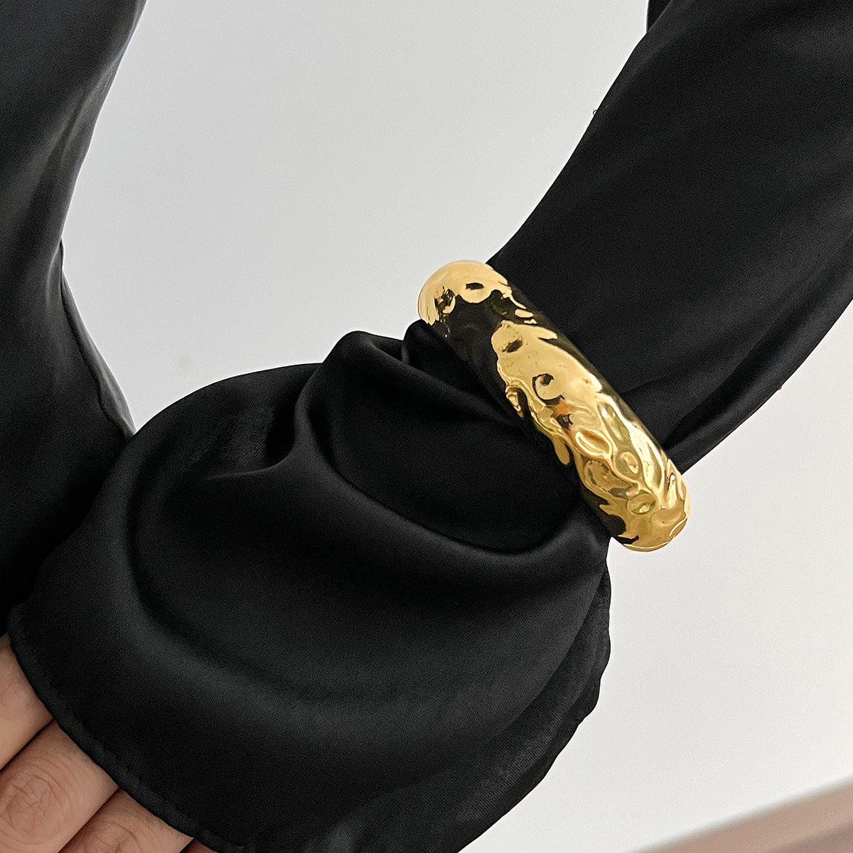 Bracciale rigido a molla lucidato in metallo liquido geometrico con texture decisa da donna