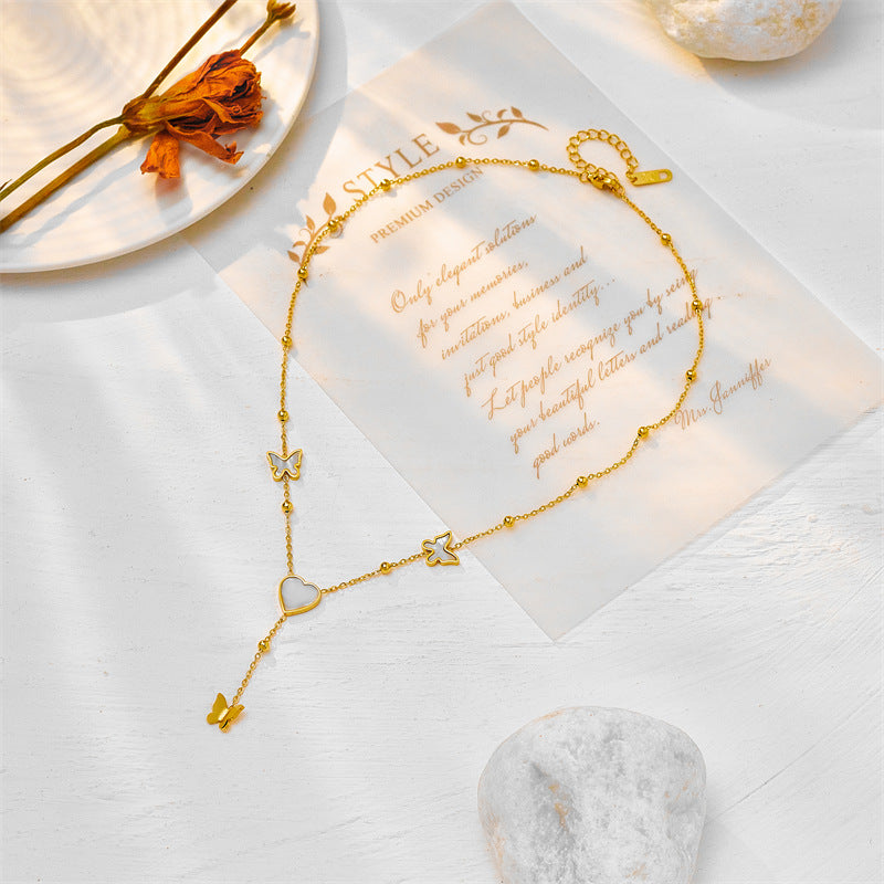 Collar con colgante minimalista de corazón y mariposa con borlas de acero titanio con acabado chapado para mujer