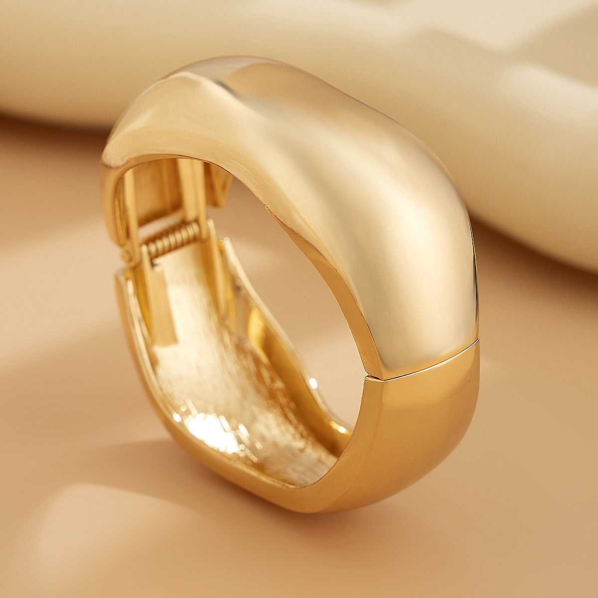 Bracciale rigido da donna in metallo audace con design geometrico, superficie lucida e finitura placcata