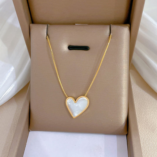Collana da donna minimalista con ciondolo a cuore in acciaio al titanio e madreperla, con placcatura in oro e catenina a maglie.