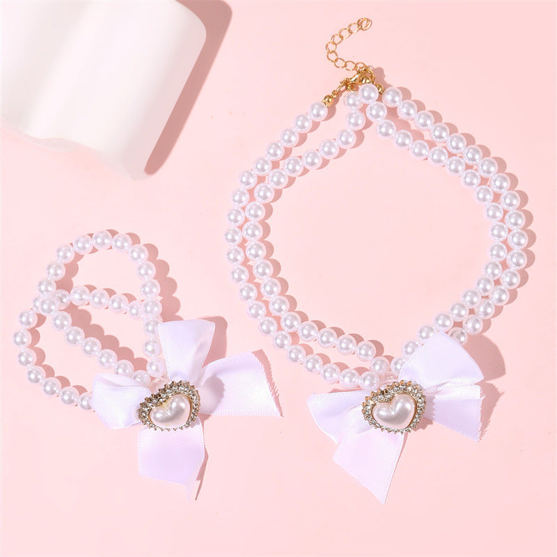 Elegante collar de perlas de doble capa para niñas con lazo y colgante de corazón en estilo estético crema, joyería de resina