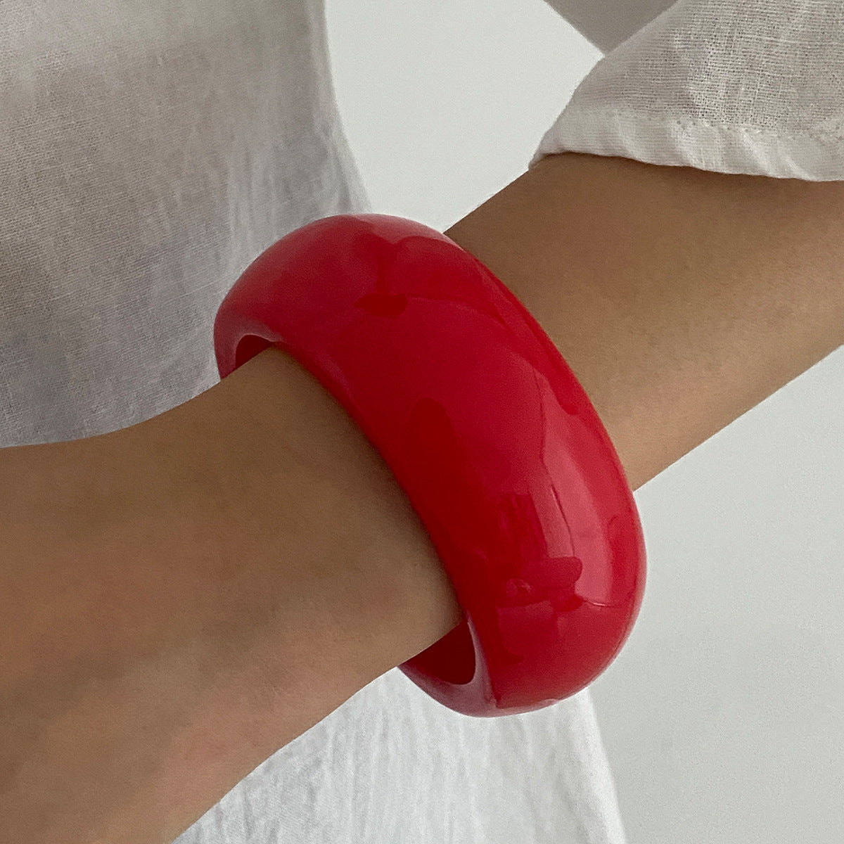 Pulsera geométrica en contraste rojo vivo con acabado pulido y superficie galvanizada para mujer