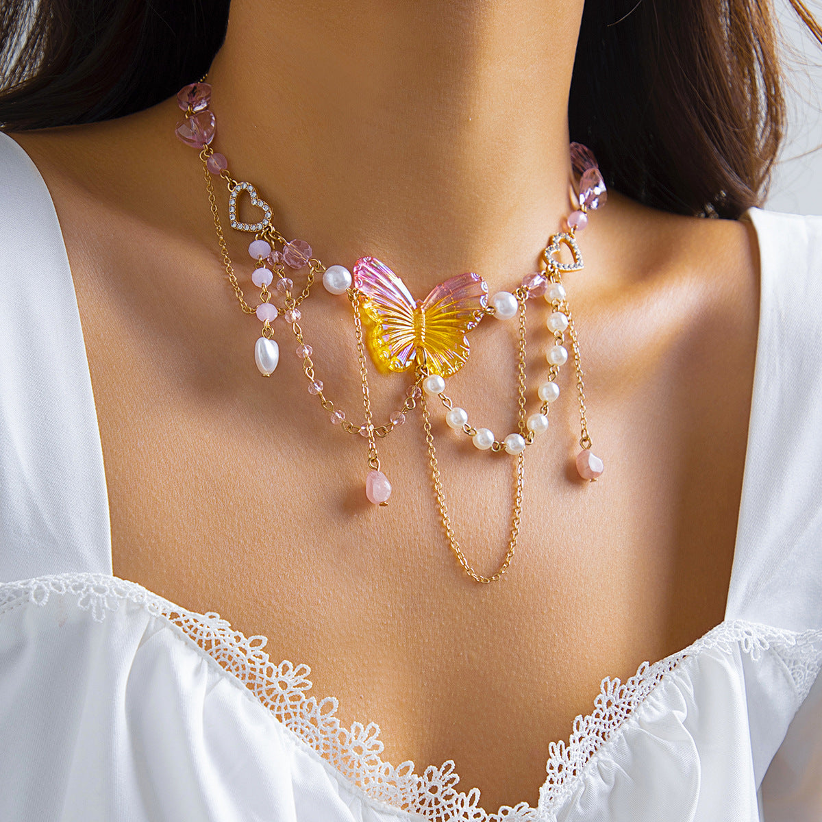 Collana con ciondolo a farfalla fragola rustico chic da donna con dettagli in perle sintetiche e frange su catena di perle