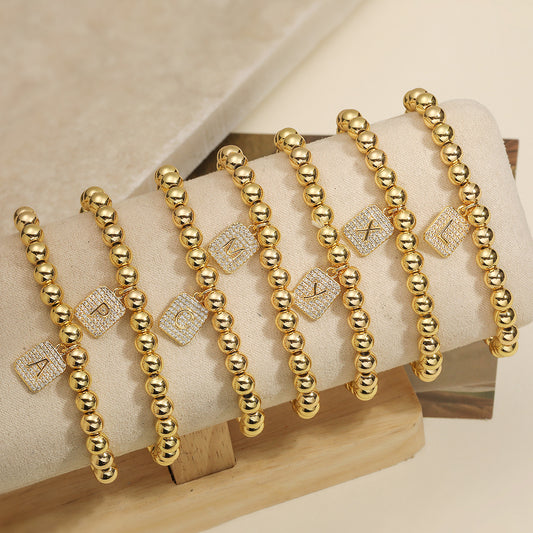 Pulsera Minimalista con Colgante de Letra Personalizada para Mujer con Cuentas de Cobre y Acabado Chapado en Oro de 18K