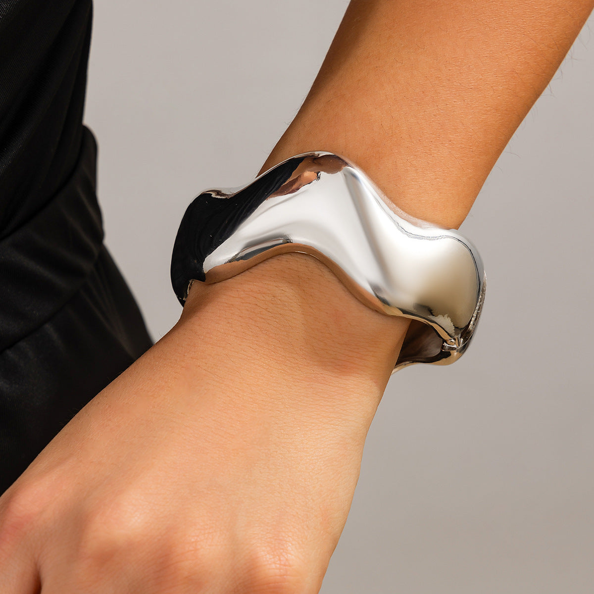 Bracciale rigido da donna in metallo audace con design geometrico, superficie lucida e finitura placcata