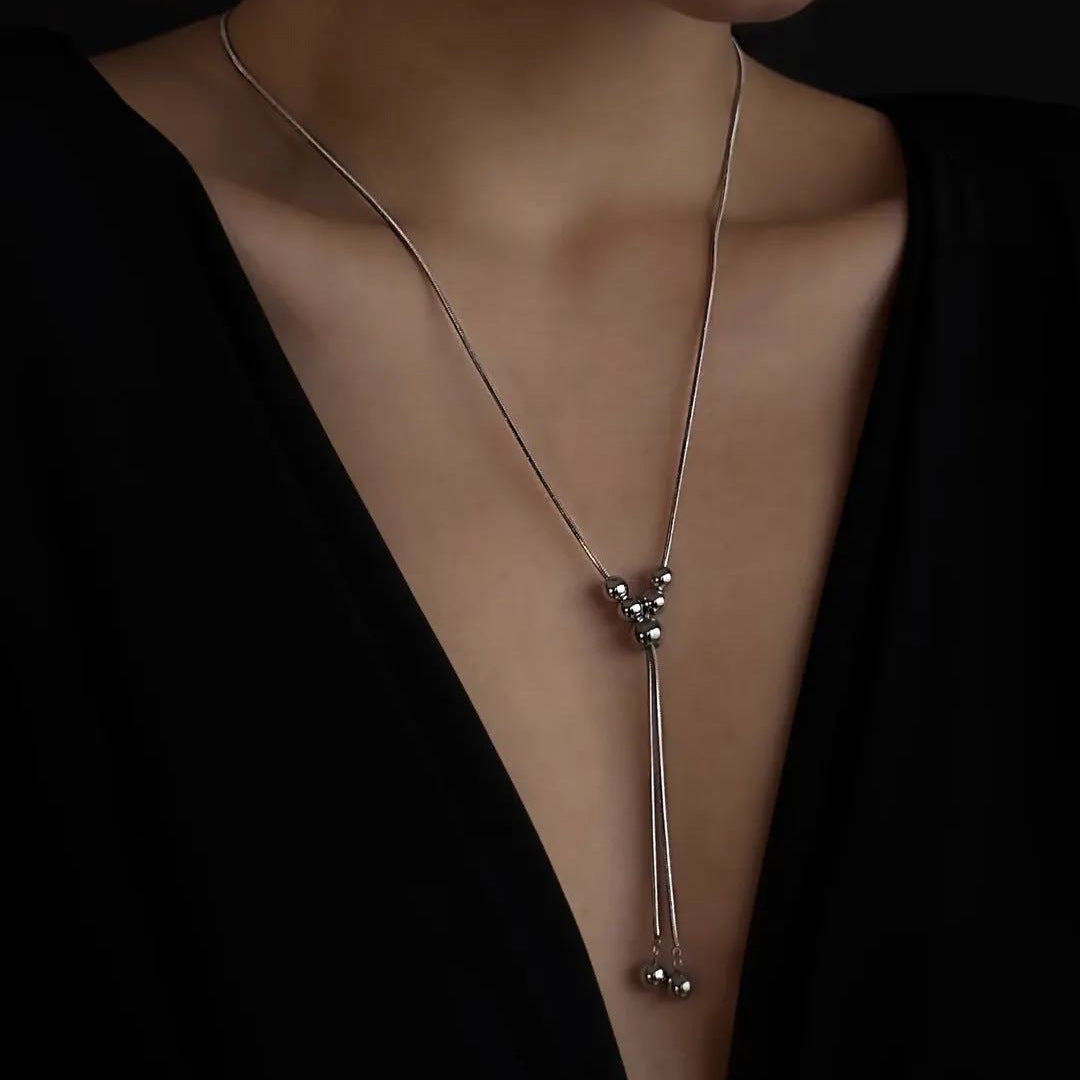 Collana da donna a sfera pendente in acciaio inossidabile dai toni freddi, con dettagli a nappa su catena a serpente regolabile, in stile minimalista