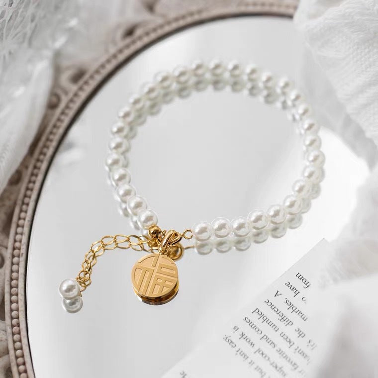 Bracciale minimalista geometrico in acciaio al titanio con pendente a carattere "Fu" placcato oro 18K e nappe di perle