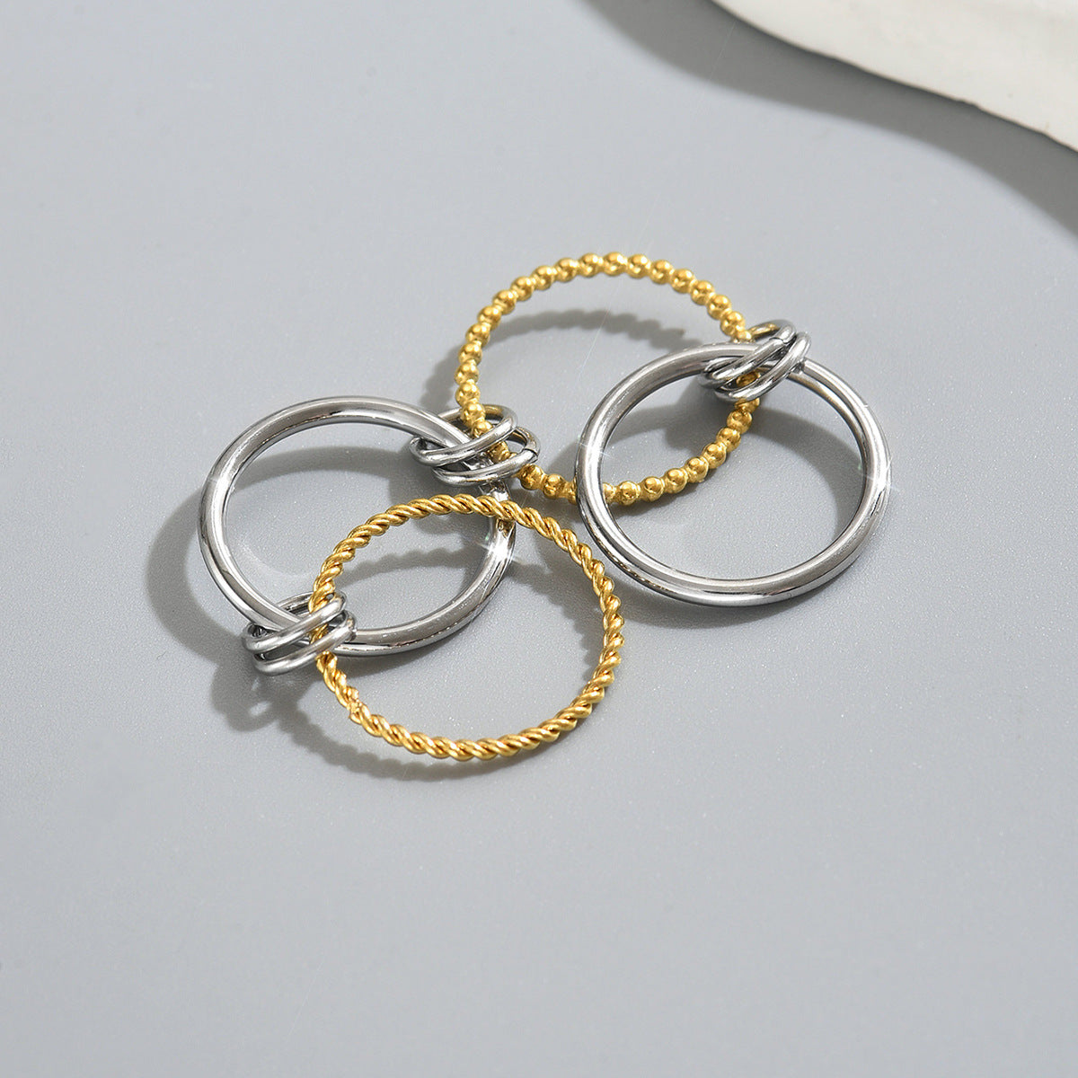 Set de anillos apilables geométricos cruzados para mujer en cobre con baño de oro de 18K
