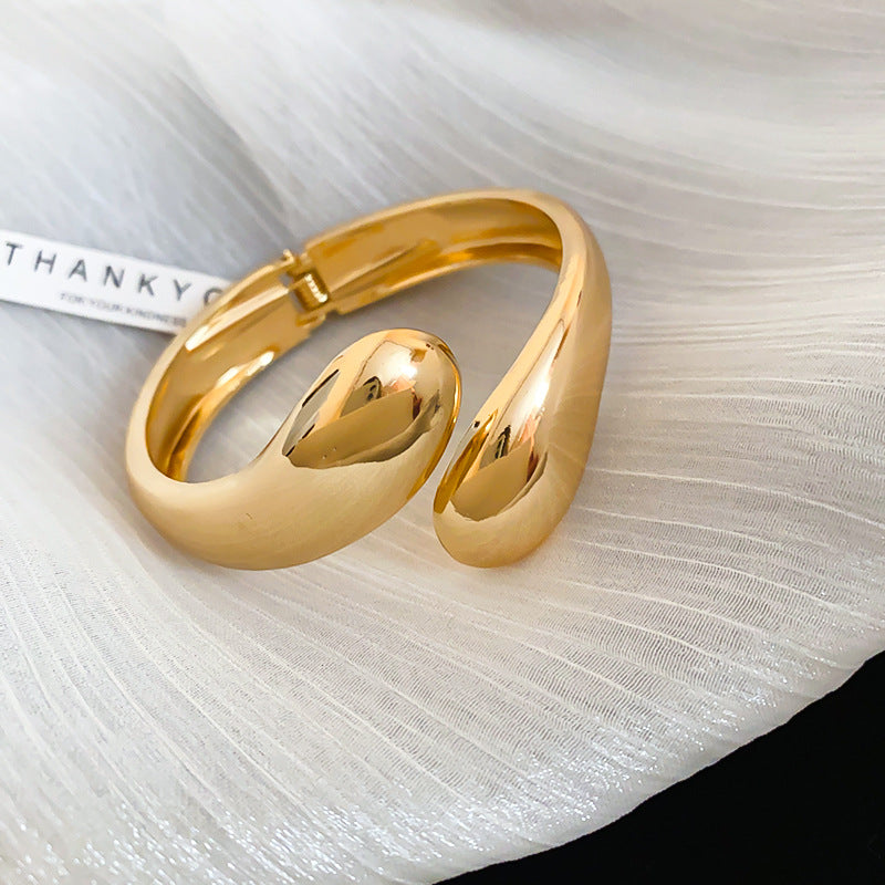 Bracciale rigido minimalista in metallo regolabile da donna con finitura placcata e sottile accento a goccia