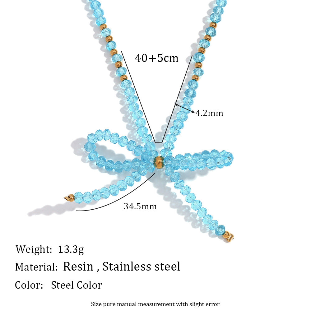 Elegante collar con colgante de acero inoxidable en forma de lazo para mujer con detalles de cristal facetado azul y acabado galvanizado
