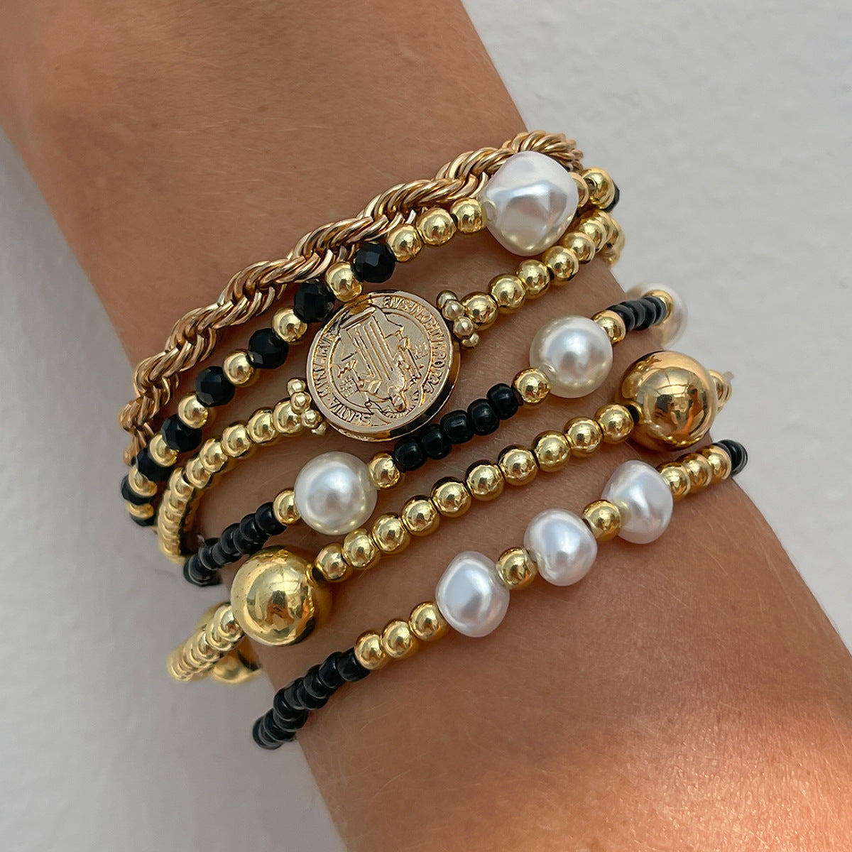 Bracciale in stile bohémien con perline colorate, ciondolo a croce in perla sintetica e nappine decorative