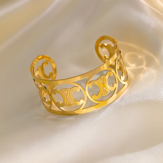 Elegante pulsera de acero de titanio con diseño geométrico calado y baño de oro de 18 quilates para mujer
