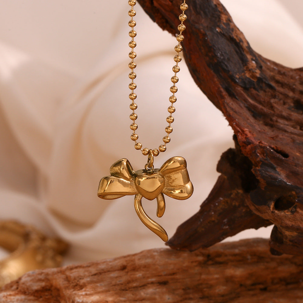 Collana con ciondolo a fiocco alla moda da donna in acciaio inossidabile con placcatura in oro 18 carati su catena di perline rotonde