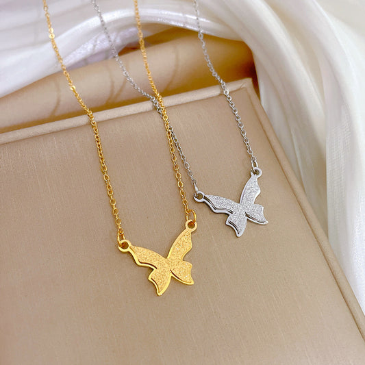 Collana minimalista con ciondolo a farfalla in titanio opaco e acciaio placcato oro con dettagli di perline geometriche per donna