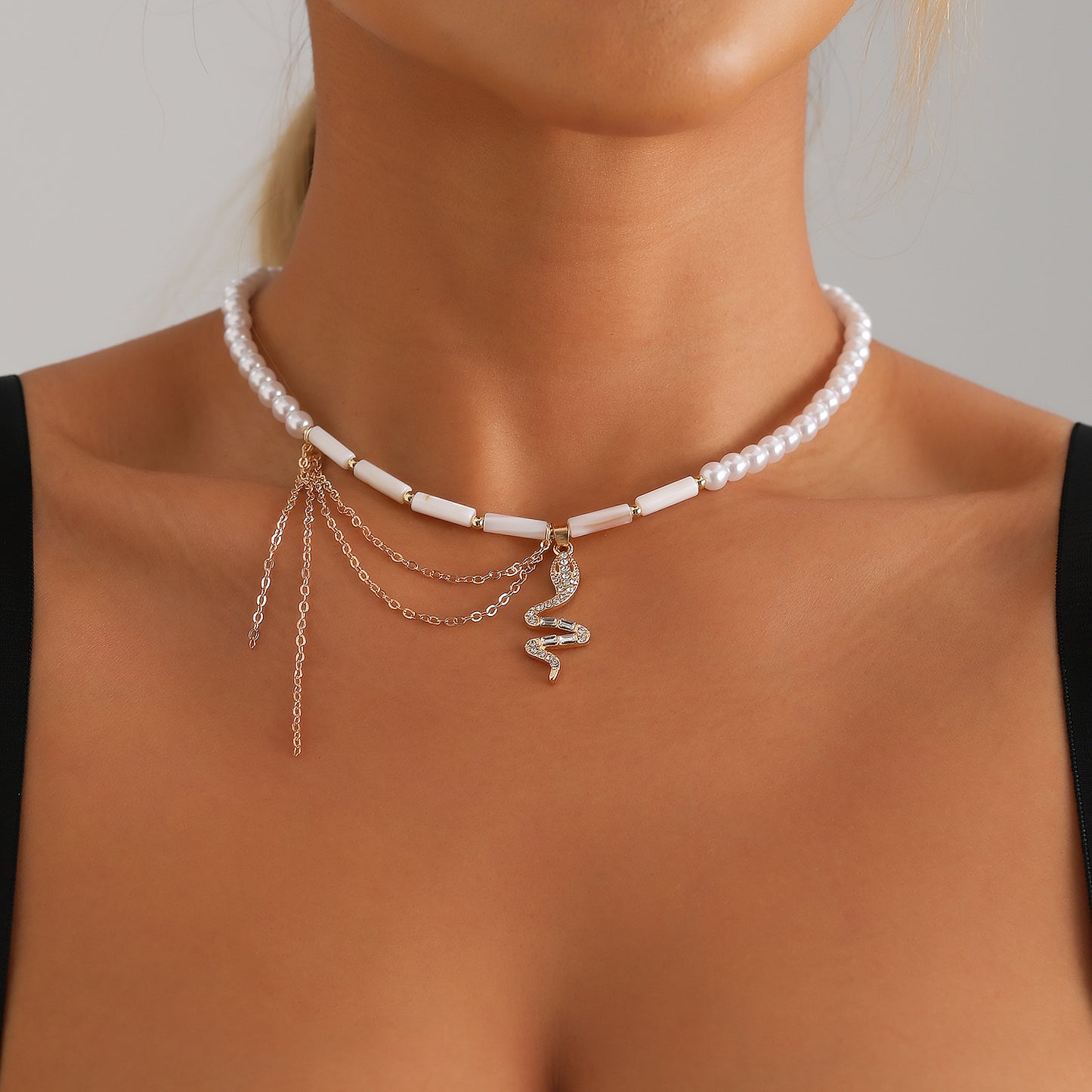 Collana girocollo a serpente minimalista con ciondolo a nappa e accenti di cilindri in perle d'imitazione su catena placcata oro in lega per donna