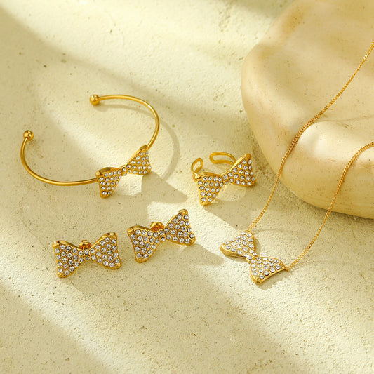 Set di orecchini, collana e anello da donna in acciaio al titanio a forma di fiocco, stile lussuoso, con finitura placcata