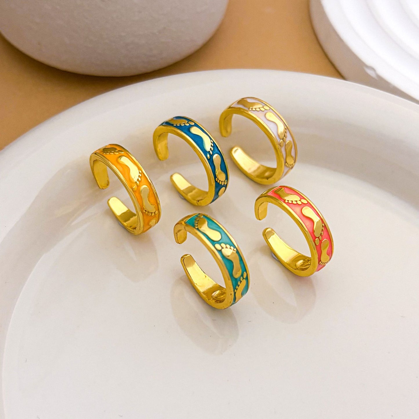 Anello aperto da donna placcato oro con smalto e piedino in stile fumetto