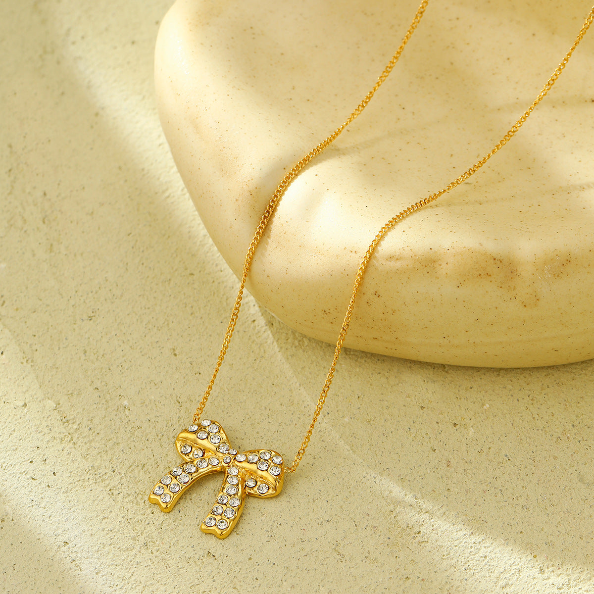 Orecchini di lusso da donna in acciaio al titanio a forma di fiocco con intarsio di strass completo e finitura placcata
