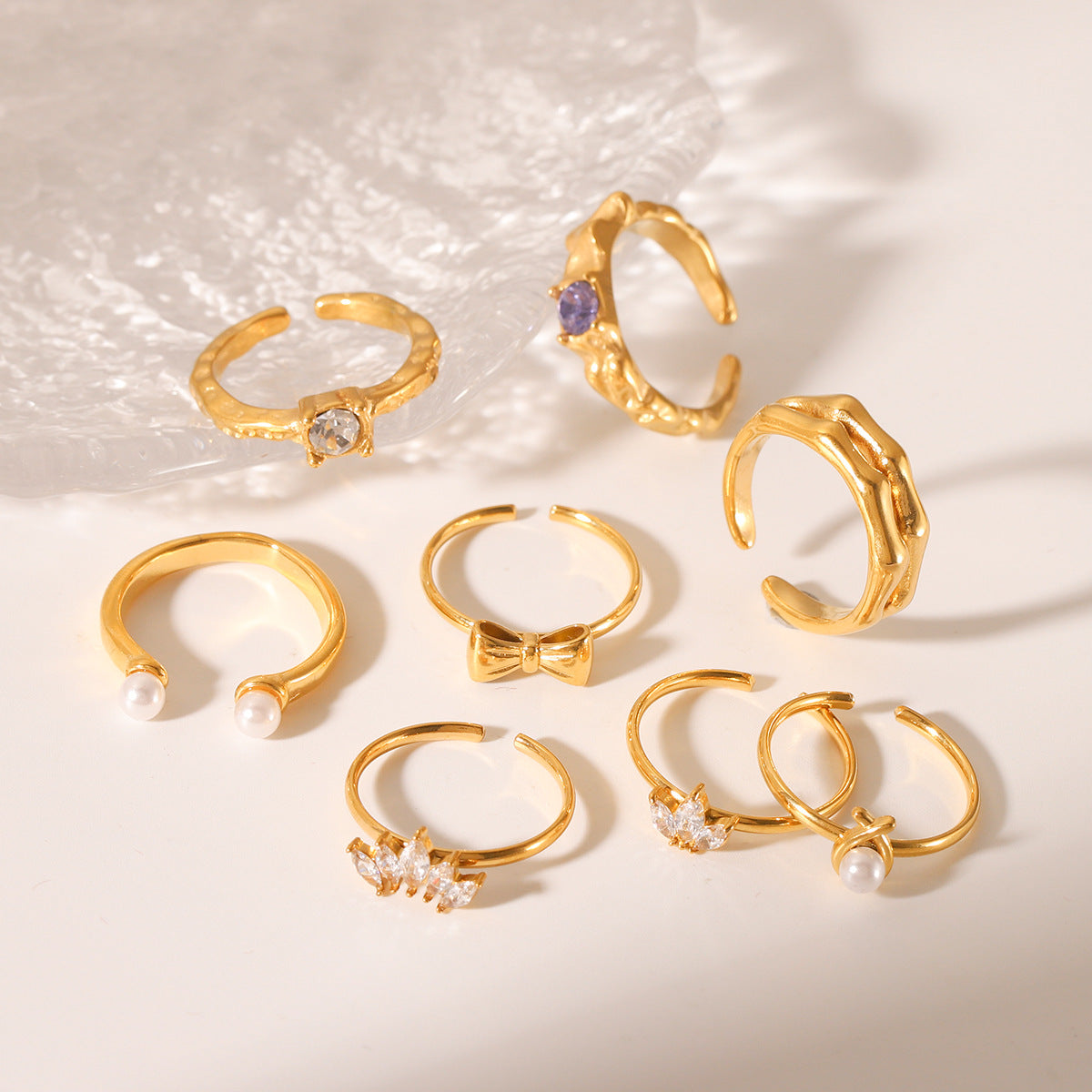 Anello da donna alla moda placcato oro 18 carati in acciaio inossidabile martellato a forma di fiocco con perla e zircone