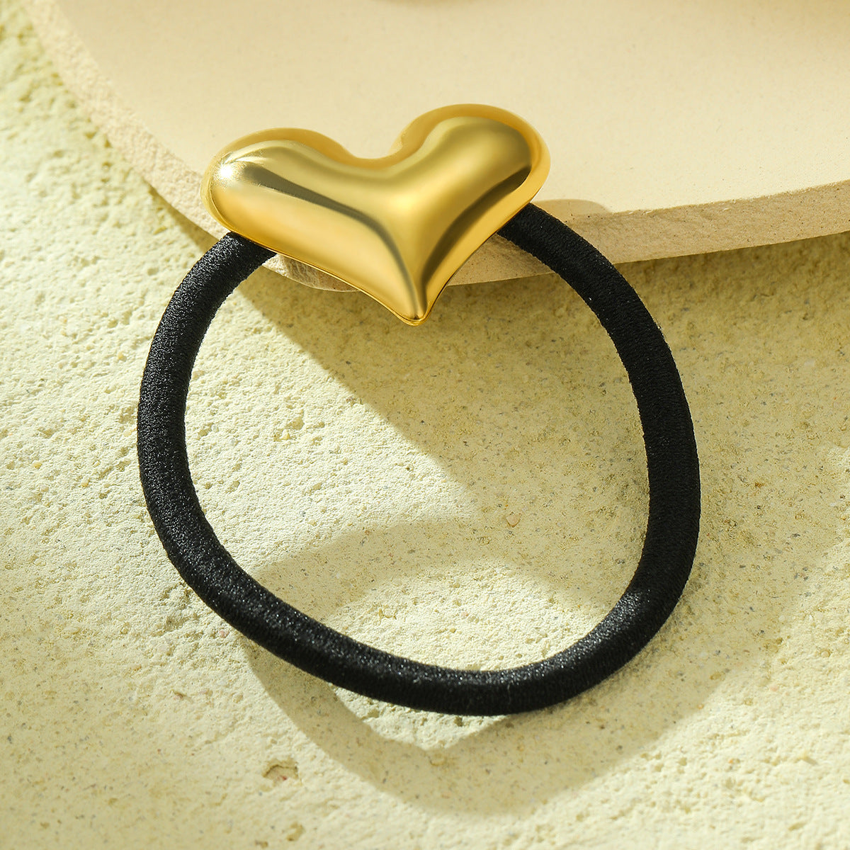 Goma de pelo minimalista de acero de titanio con forma de corazón y acabado chapado para cola de caballo, elegante banda elástica negra